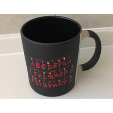 Cargar imagen en el visor de la galería, Taza Magica Stranger Things Fondo Negro Abecedario Run